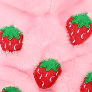 Close-up of soft pink plush pet fabric with embroidered strawberry details