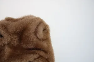 Close-up of soft brown plush fabric texture for autumn and winter small dog clothes.