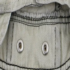 Close-up detail of pet denim vest featuring metal buttons and black stitching