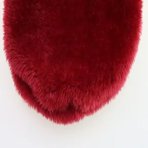 Macro view of deep red plush faux fur texture on a small dog winter vest garment