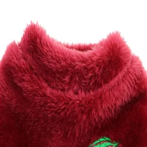 Close-up macro view of the soft wine-red plush fabric on a winter dog vest collar detail