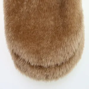 A high-resolution macro detail of soft brown plush faux fur fabric for pet winter clothes.