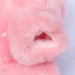 Detail shot showing the macro texture of pink soft plush fabric on winter pet clothing.
