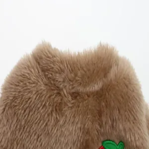 Close-up of soft plush texture on brown pet winter vest with leaf embroidery detail.