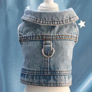 Macro view of blue denim pet vest showing durable metal D-ring and stitching details.