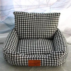 Detailed view of houndstooth pet bed with plush interior and decorative logo tag.