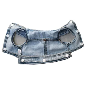 Macro detail view of denim pet vest showing white snap buttons and inner lining