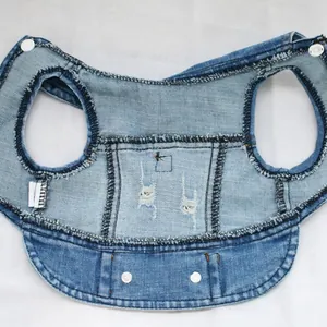 Detailed inside view of a distressed blue denim dog vest featuring sturdy button closures.
