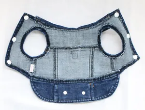 Close-up detail of denim dog harness vest with snap buttons and stitching
