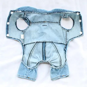 Detail view of denim pet jumpsuit interior with white snap buttons and frayed edges