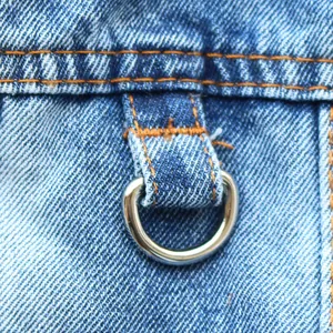 Macro detail of heavy duty metal D-ring on blue denim pet harness vest