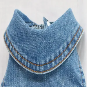 Macro view of a blue denim dog vest featuring a classic collar and durable stitching