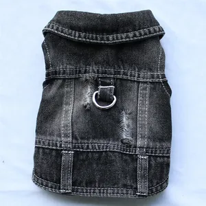 Detail van zwart versleten denim hondenvest met metalen D-ring voor riembevestiging