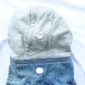 Macro detail of the snap buttons and gray knitted hood on a blue denim pet vest harness