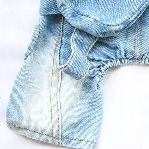 Close-up of light blue dog denim jumpsuit showing fabric texture and contrast orange stitching