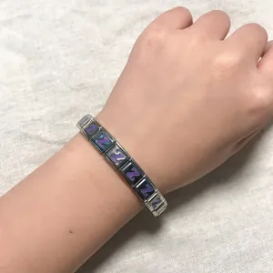 Detail view of a stainless steel Italian charm bracelet with purple letter Z charms on wrist