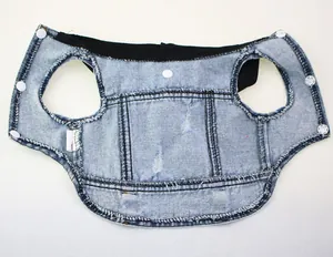 Macro detail of a light blue distressed pet denim vest with a black hood and snap closure