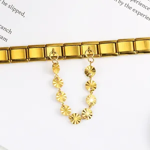 Detail of a gold stainless steel Italian modular bracelet with a sunburst charm chain.