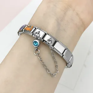 Close-up of Italian modular charm bracelet with blue birthstone and chain detail.
