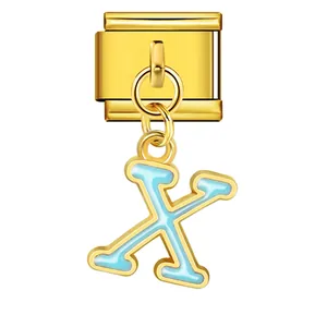 Close-up of gold stainless steel modular bracelet charm featuring a blue enamel letter X