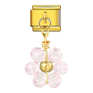 Dettaglio charm italiano con pendente fiore in cristallo rosa e finitura dorata