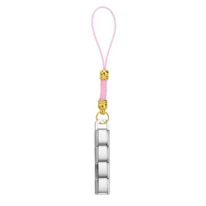 Detailaufnahme eines Edelstahl-Anhängers mit rosa Kordel und goldenen Akzenten