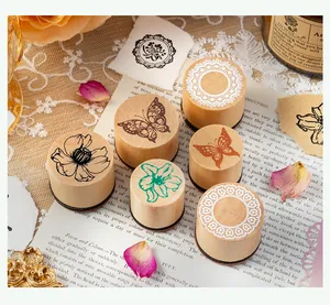 Detailed view of six vintage wooden stamps with butterfly and floral patterns for scrapbooking