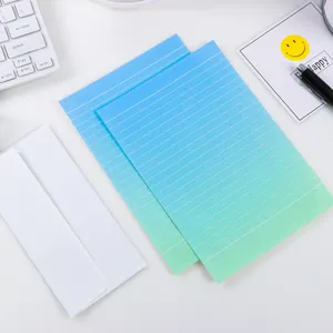 Detailopname van gelinieerd briefpapier met een blauw-groen verloop en witte enveloppen
