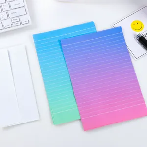 Detailopname van gelinieerd briefpapier met kleurverloop en diverse bureau-accessoires