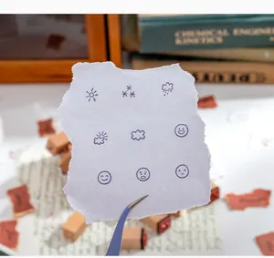 Detailed view showing weather and emotion icons stamped on paper for planner decoration