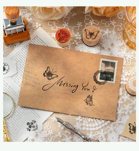 Detail of butterfly and floral wooden stamp set on vintage envelope for DIY