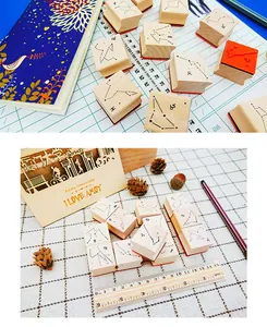 Detailed view of 12 zodiac constellation wooden stamps for DIY scrapbooking.