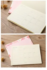 Macro view of portable weekly planner layout with elegant floral design on wood surface