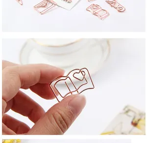 Detailed close-up of a rose gold book-shaped metal paper clip with heart engraving.