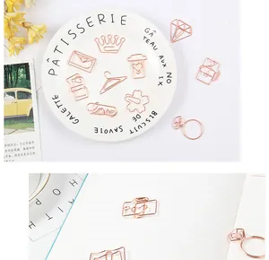 Close-up of rose gold decorative metal paper clips in heart and diamond shapes