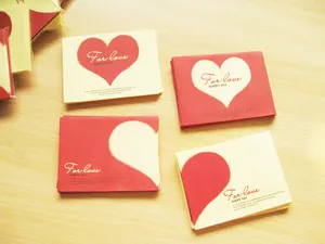 Vista detallada de los mini sobres con corazones rojos y blancos y texto For love.