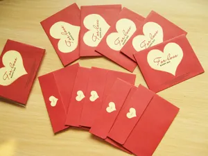 Detalle de mini sobres rojos con motivos de corazones y texto For Love Happy Day.