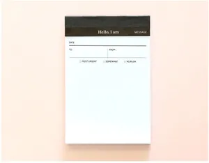 Dettaglio ravvicinato di un blocco note aziendale minimalista con sezioni per messaggi