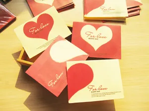 Primer plano de minisobres con diseños de corazones rojos y mensaje For Love
