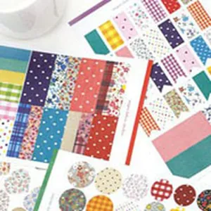 Vista dettagliata di vari fogli di adesivi decorativi colorati con motivi floreali e a quadri