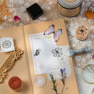Vintage wooden cylindrical stamp set with butterfly and floral motifs for DIY scrapbooking