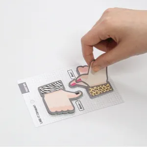 Creative thumb-shaped sticky notes with zebra and leopard patterns on a white grid backing card