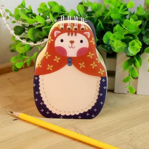 Creative cartoon cat shaped spiral notepad with red floral headscarf design on wood table