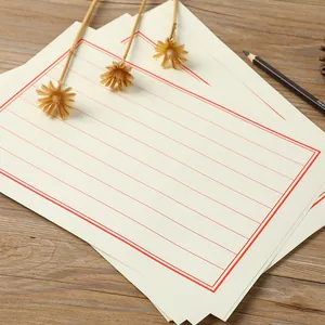 Traditional Chinese style stationery paper with red grid lines on wooden background