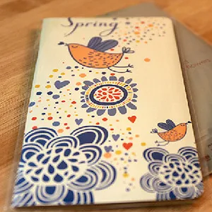 Notizbuch im Frühlingsdesign mit Vogel- und Blumenillustrationen.
