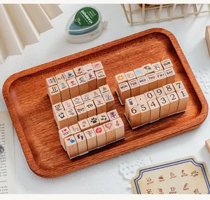 Assorted wooden stamps with icons and text for DIY journaling decoration on a tray