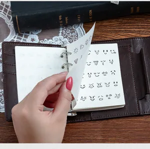 Detail view of DIY planner with cute emoji and weather stamp prints in a binder