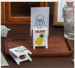 Detailed shot of creative wooden memo clips featuring cute pineapple and plant designs on a tray