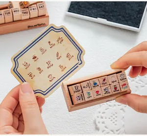 Set of 12 mini wooden diary stamps with decorative icons and English labels for journaling