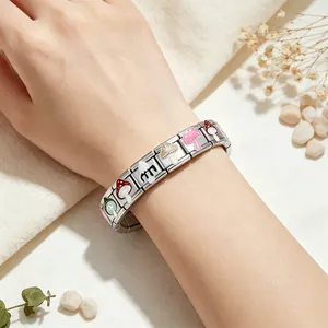 Close-up of stainless steel Italian charm bracelet with colorful mushroom patterns.